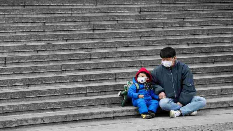 Homem sentado junto com criança na Coreia do Sul