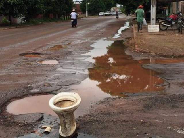 Boneco sentado em vaso sanitário foi colocado em rua com esgoto a céu aberto - Reprodução Facebook