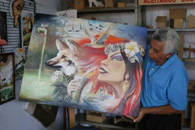 Valdeco mostra quadro surrealista que pintou. "A gente viaja mais" (Foto - Cleber Gellio/Midiamax)