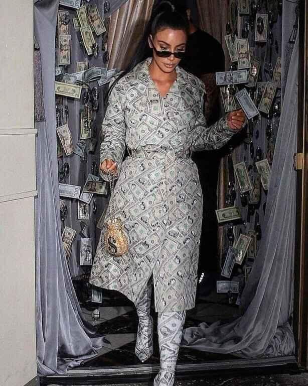 Roupa de dinheiro? Sim, Kim Kardashian ostentou com sobretudo e botas estampadas com notas de dólares.