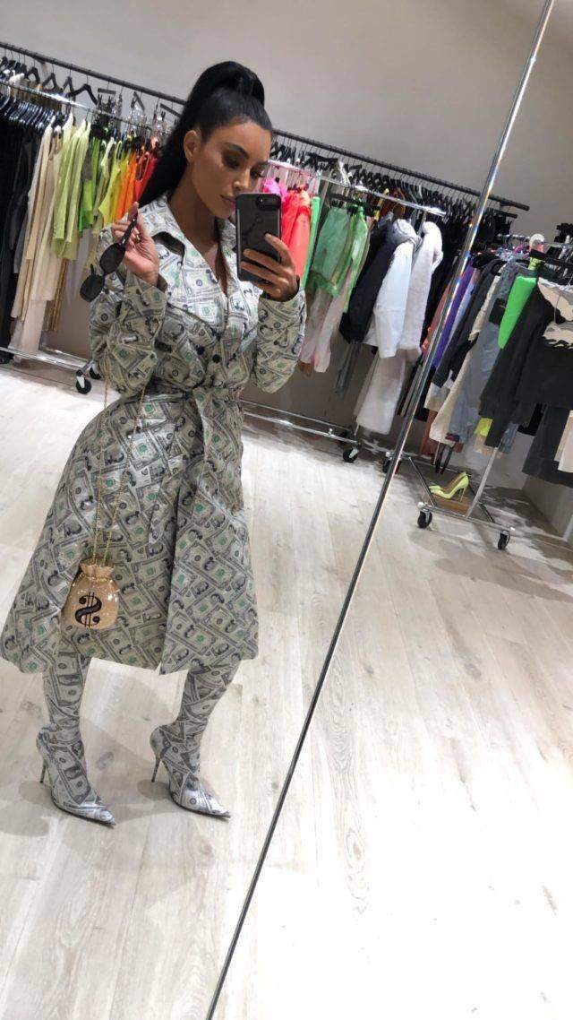 Roupa de dinheiro? Sim, Kim Kardashian ostentou com sobretudo e botas estampadas com notas de dólares.