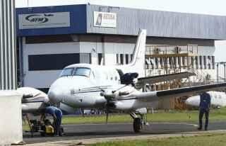 Piloto encapuzado brinca com a imprensa no aeroporto de Campo Grande