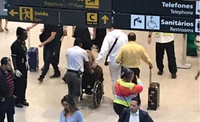 Alcione cai em escada rolante de aeroporto e é levada em cadeira de rodas