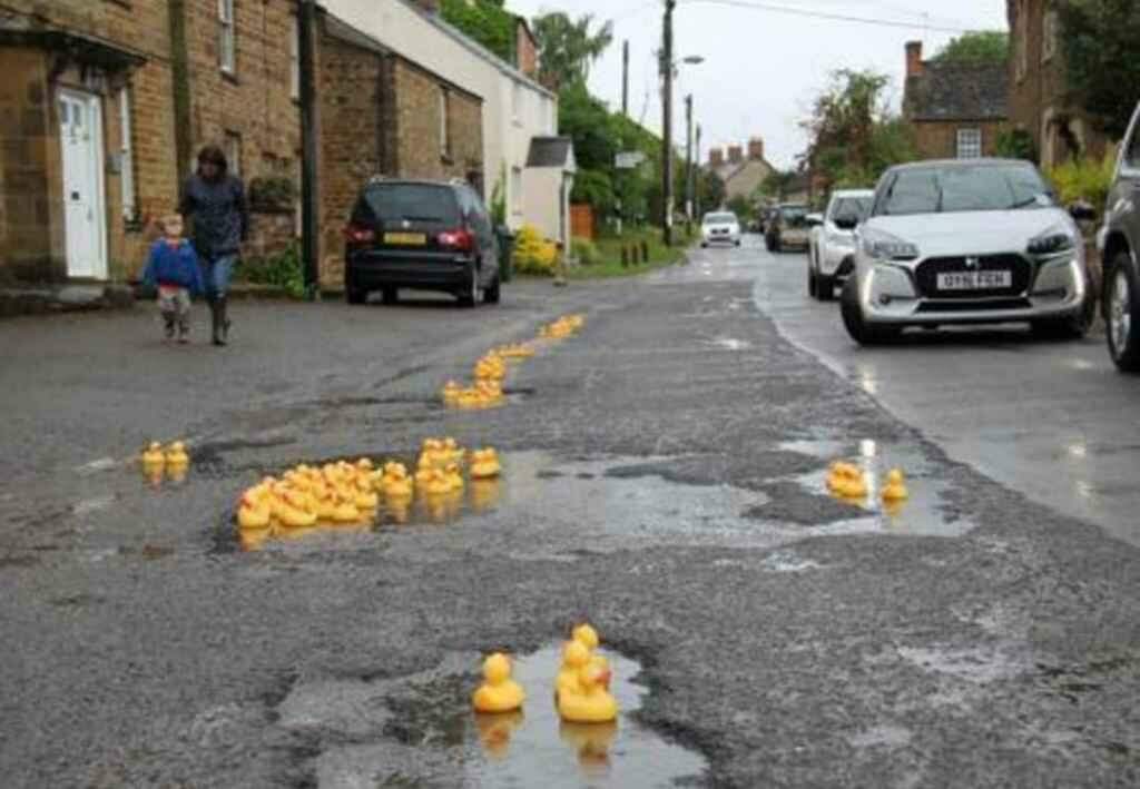 Moradores enchem buracos nas ruas com patos de borracha