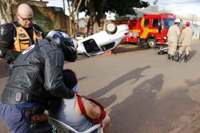 Carro capota em cruzamento que tem placas escondidas por árvores e 3 ficam feridos