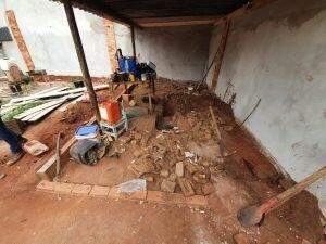 Com mini escavadeira, polícia desenterra quase 20 armas, munições e drogas em quintal