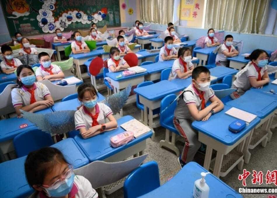 Na China, alunos usam “asa de um metro” para manter o distanciamento social.