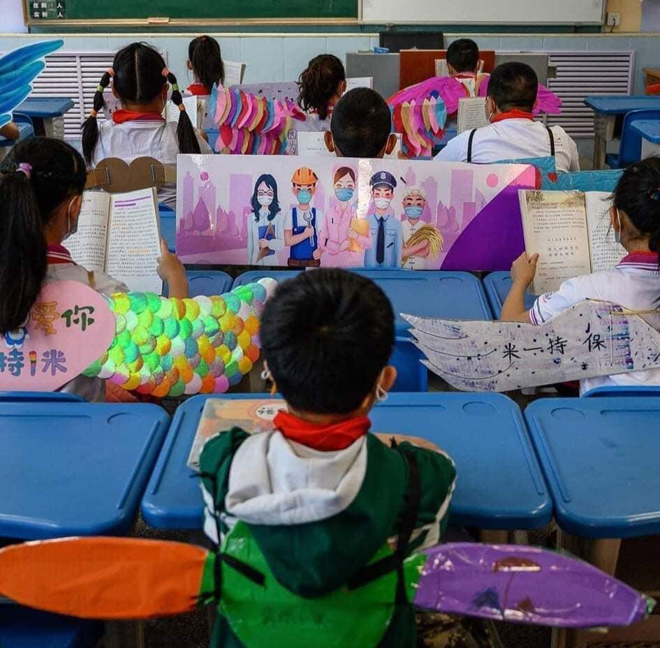 Na China, alunos usam “asa de um metro” para manter o distanciamento social.