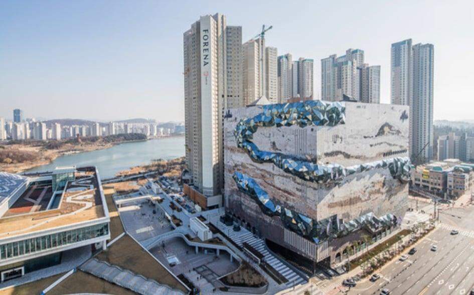 Loja sul-coreana ganha fachada com textura de pedra e mosaicos de vidro