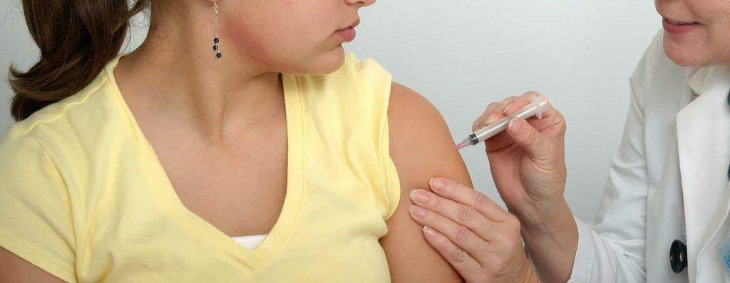mulher vacinando adolecente