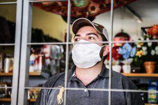 Nos bairros, comerciantes evitam circulação com grades e dão máscaras para barrar coronavírus