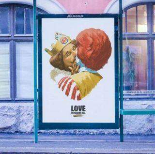 Mascote do Burger King beija Ronald McDonald em campanha.