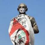 Estátua de Getúlio Vargas, morto há 66 anos, recebe máscara e bandeira do movimento  naturista  em Dourados