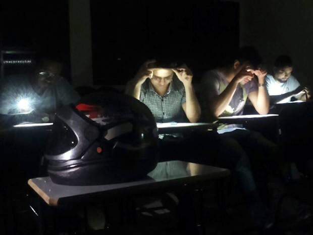 Alunos usam lanterna de celular para poder estudar durante apagão em Cuiabá