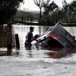 Carro capota em MS e fica parcialmente submerso em área alagada