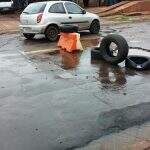 Moradores colocam pneus para sinalizar buracos com mais de um mês de vida