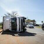 Caminhão tomba em rotatória com carga de eucaliptos avaliada em R$ 30 mil