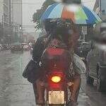 Vale tudo para não se molhar: Casal usa guarda-chuva em motocicleta em Campo Grande