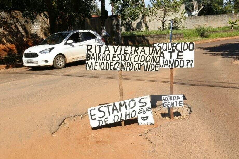 Moradores de bairro da Capital usam placas em buracos para reclamar da Prefeitura