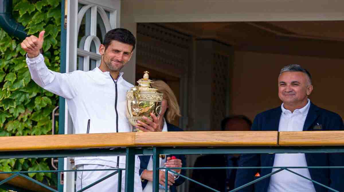 Djokovic com o troféu de Wimbledon 2021 ao lado de seu pai