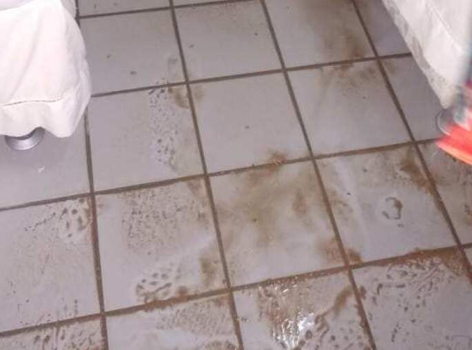 Imagem mostra piso sujo de barro após inundação em quarto de hotel