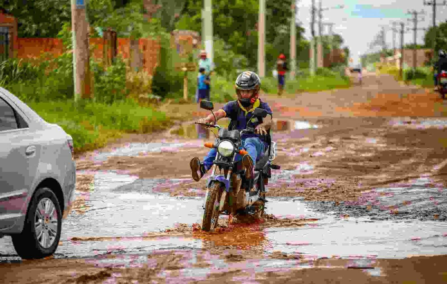 Motociclista precisa levantar as pernas para não se molhar ao transitar pela via