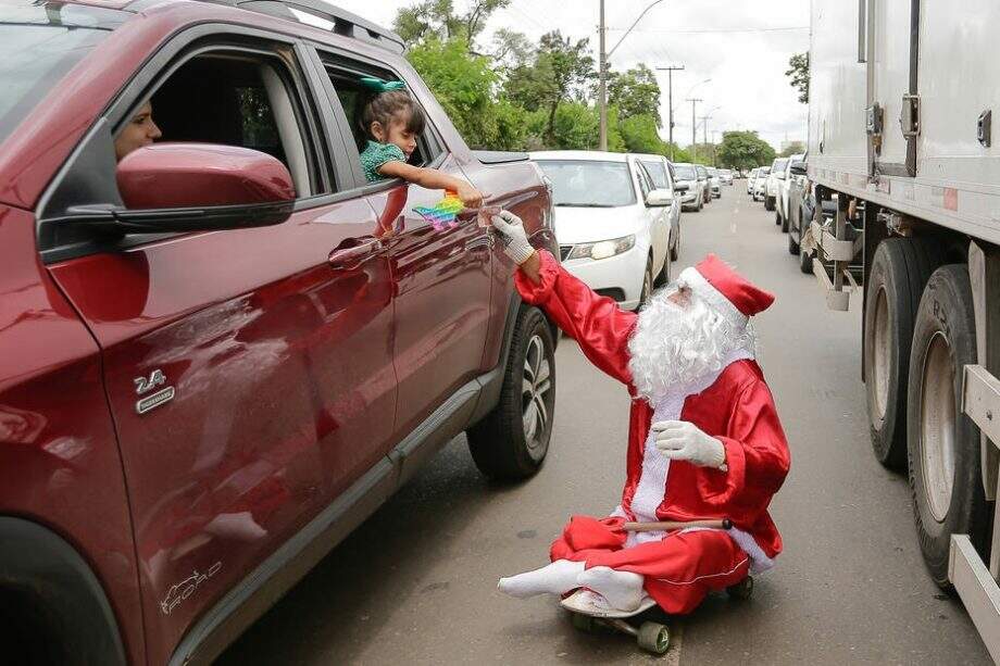 De skate, Papai Noel dribla carros e dificuldades na capital do País