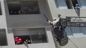 Papai Noel usa escada dos bombeiros para levar presentes a crianças com Covid
