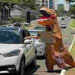 ‘Estou em extinção’: Dinossauro chama atenção ao pedir ajuda em avenida famosa de Campo Grande