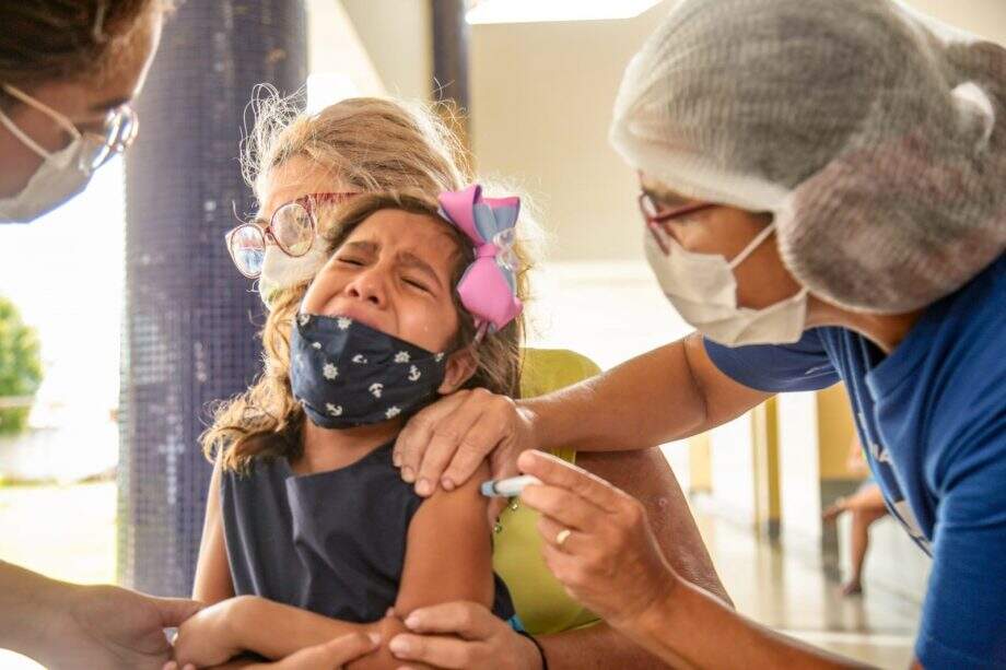 Ana Clara sendo vacinada em escola de Campo Grande nesta terça