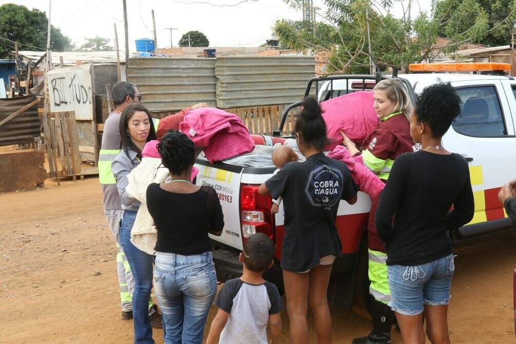 Moradores de bairros carentes recebem a doação de cobertores e sacos de dormir em Campo Grande