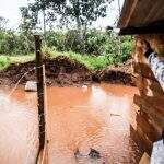 Em comunidade que sempre alaga, moradores tentam cavar vala para escoar água