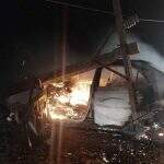 Carro é destruído por incêndio após colidir contra poste de energia em estrada vicinal