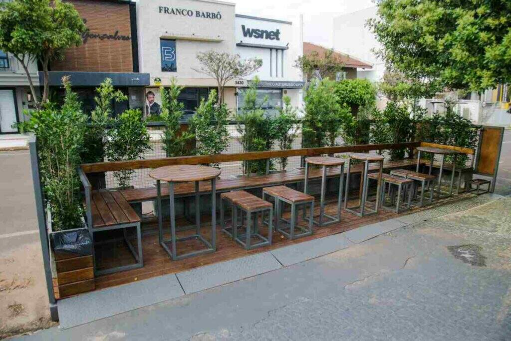 Estruturas com bancos e mesas na pista de estacionamento de ruas 